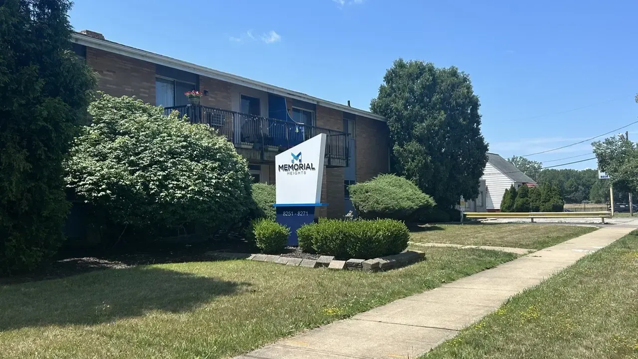 A large apartment building with a sign in front of it.