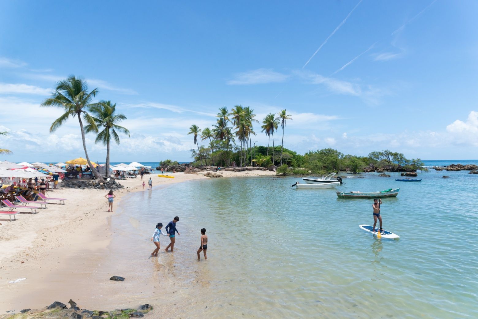 Imagem de turistas aproveitando o banho de mar em uma das praias do Morro de São Paulo.