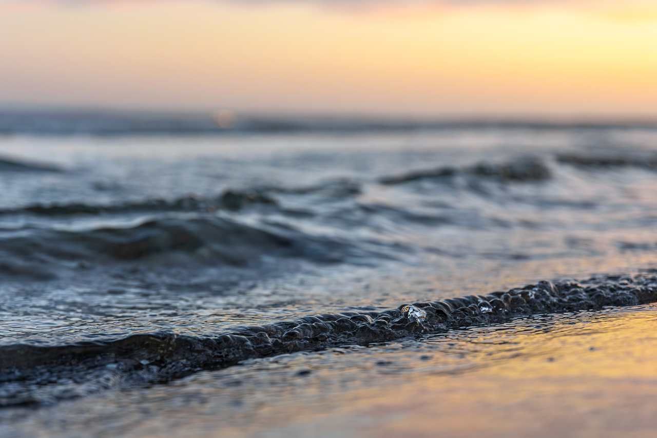 Imagem da água do mar próxima à faixa de areia, simbolizando a tábua de maré em Morro de São Paulo.