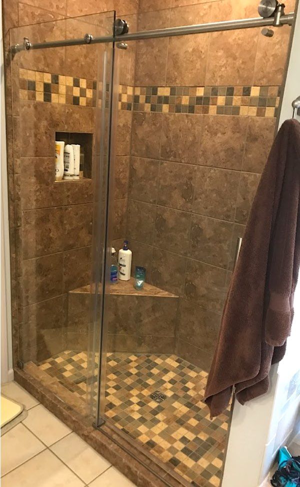 Beautiful glass shower door and inlaid tile design