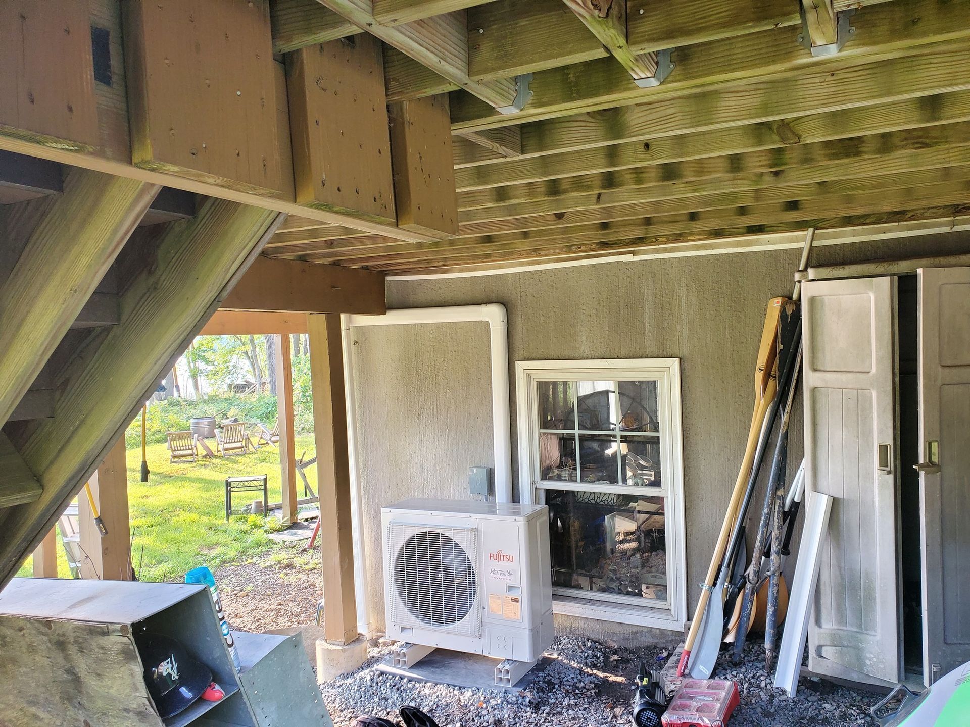 A building under construction with a window and a fan on the side of it.