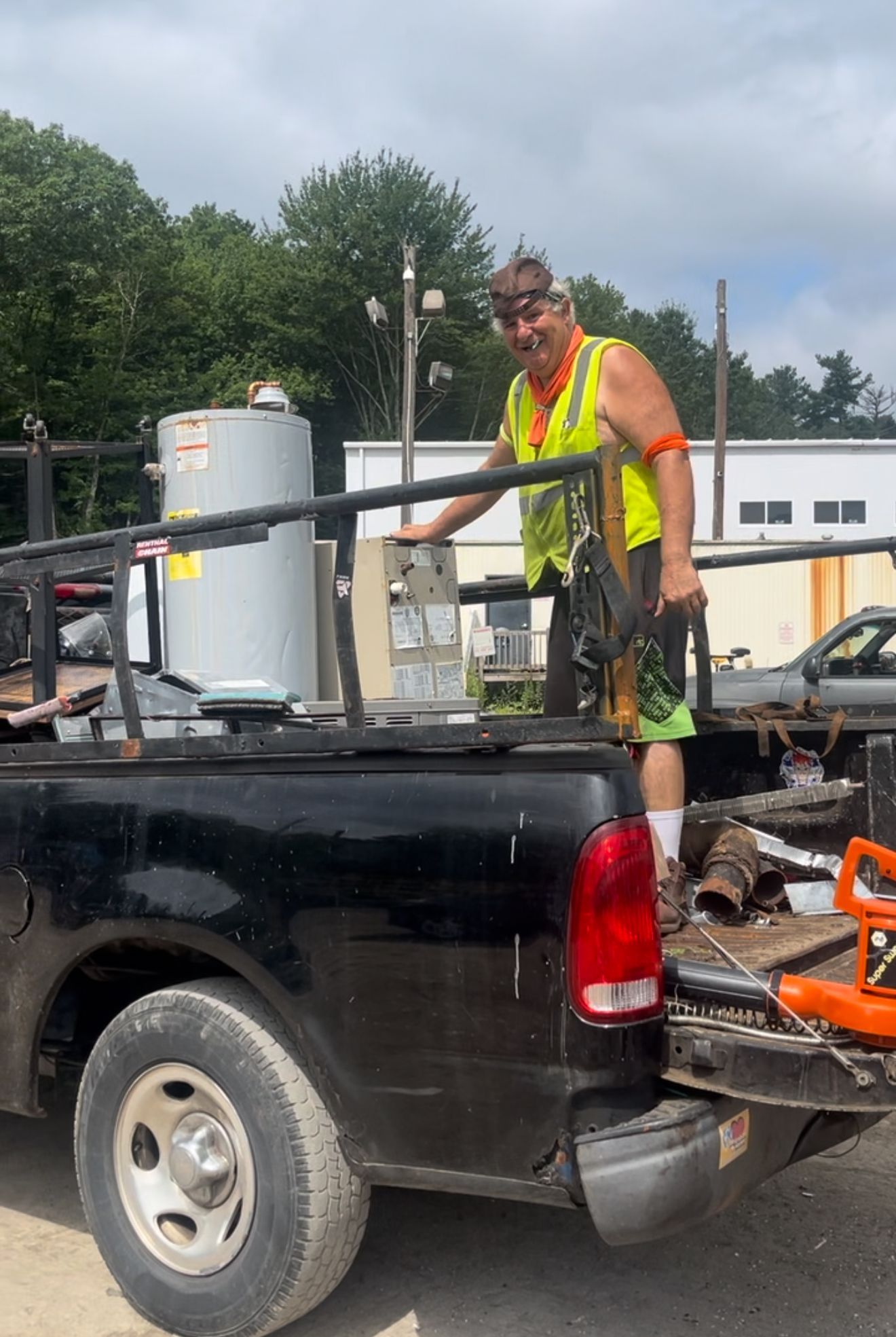 A man is standing in the back of a truck.