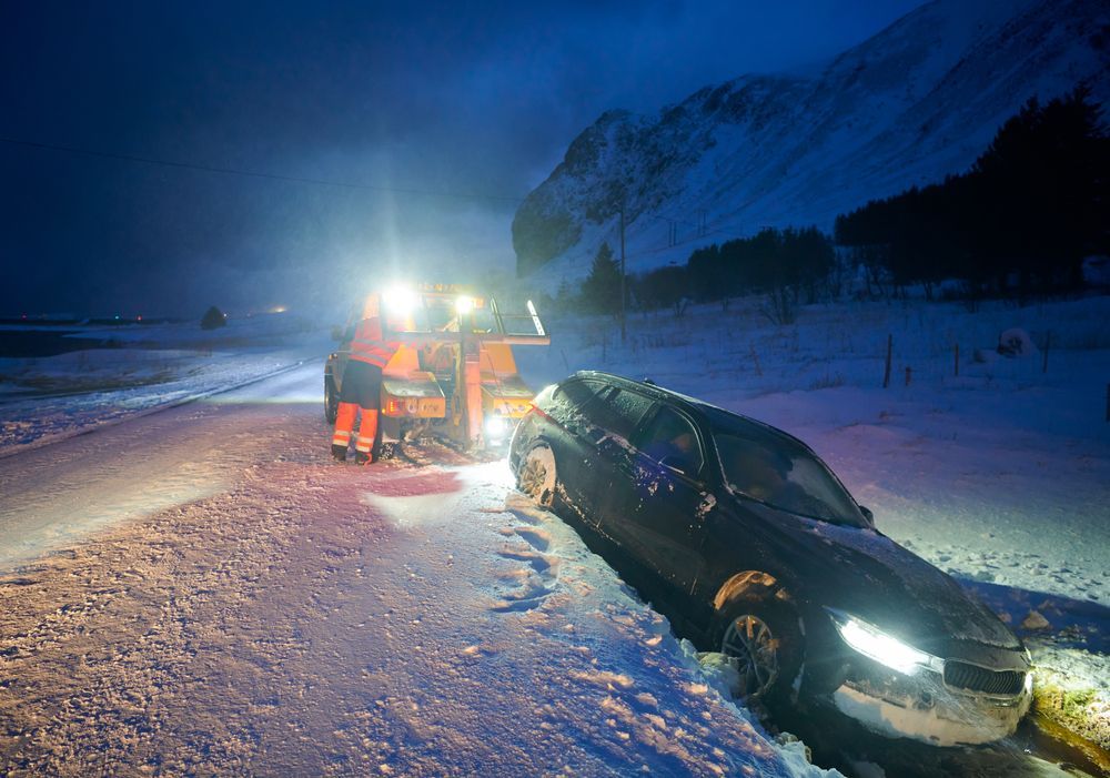 A car is stuck in the snow on the side of the road.