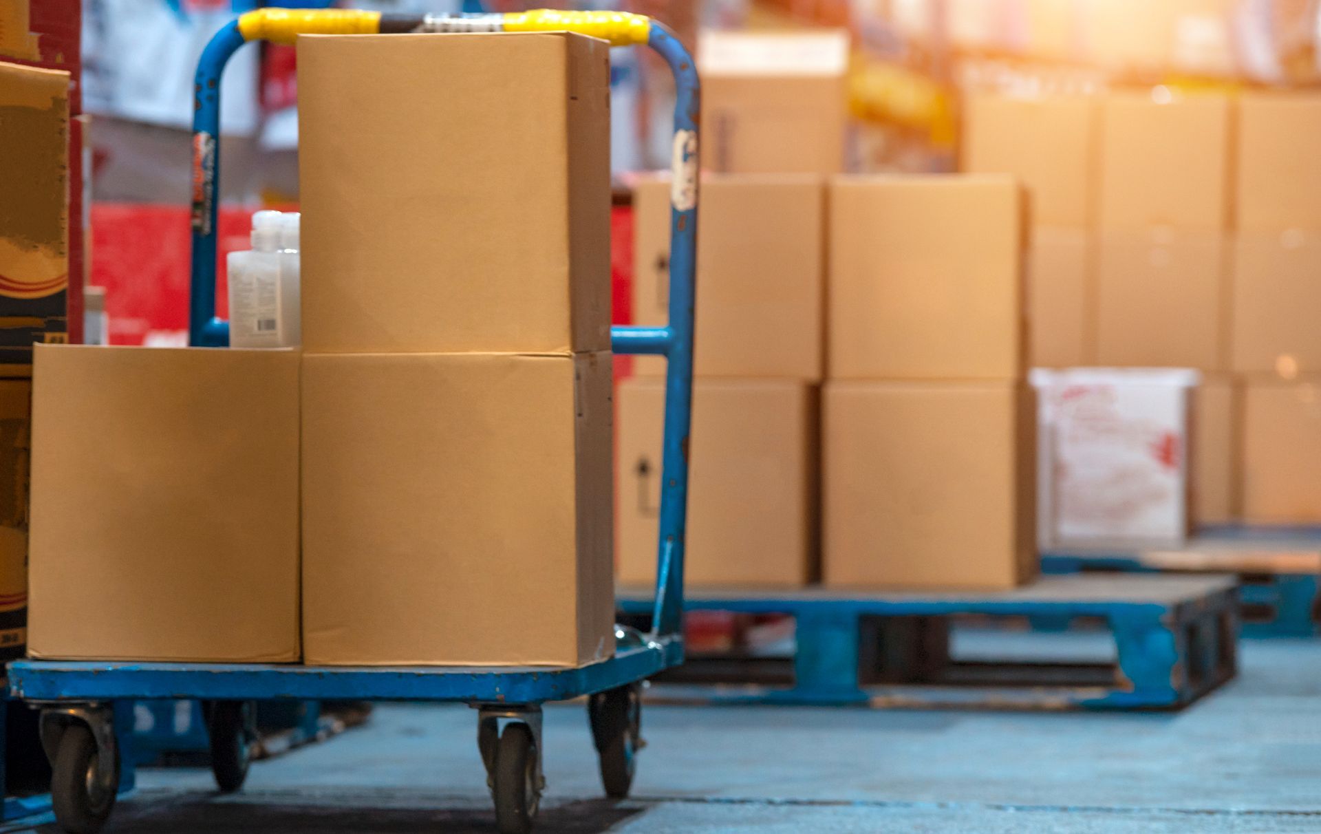 A cart filled with cardboard boxes in a warehouse.