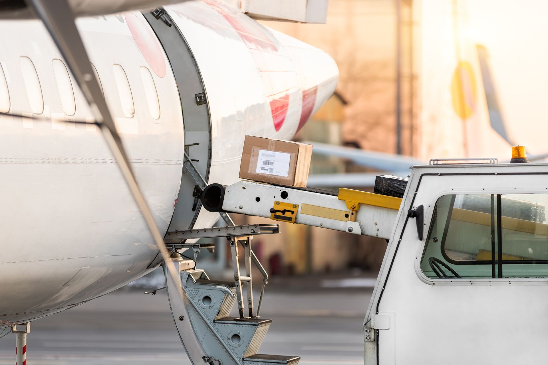 A box is being loaded into an airplane at an airport.