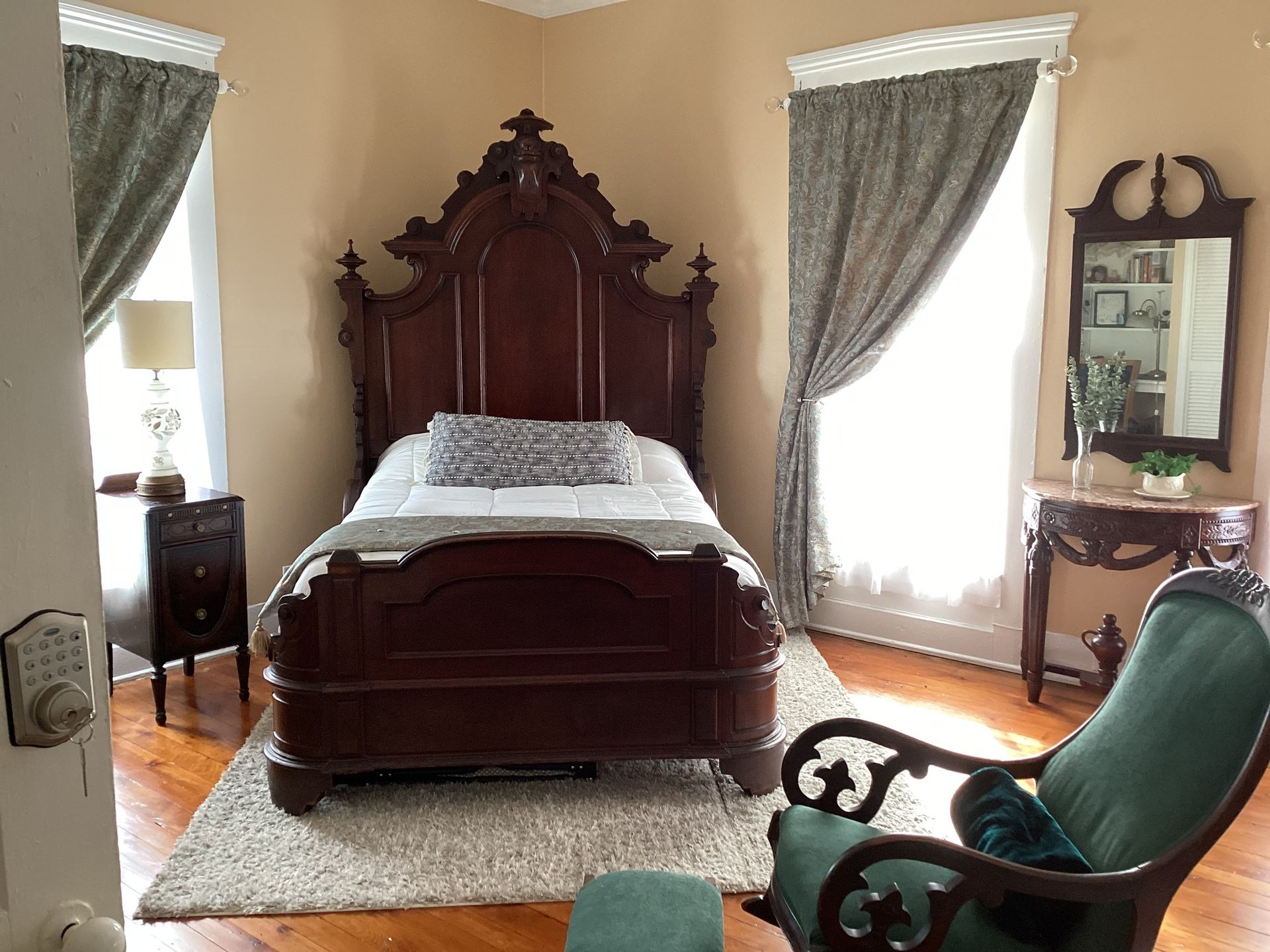 A bedroom with a bed , chair and mirror