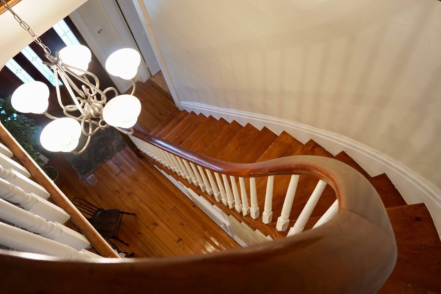 A spiral staircase with a chandelier hanging from the ceiling