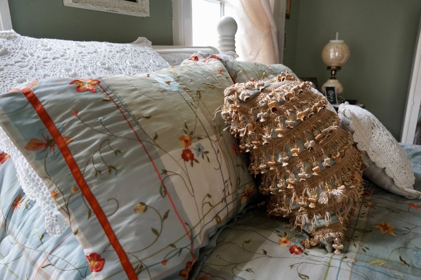 A bed with pillows and a lamp on it