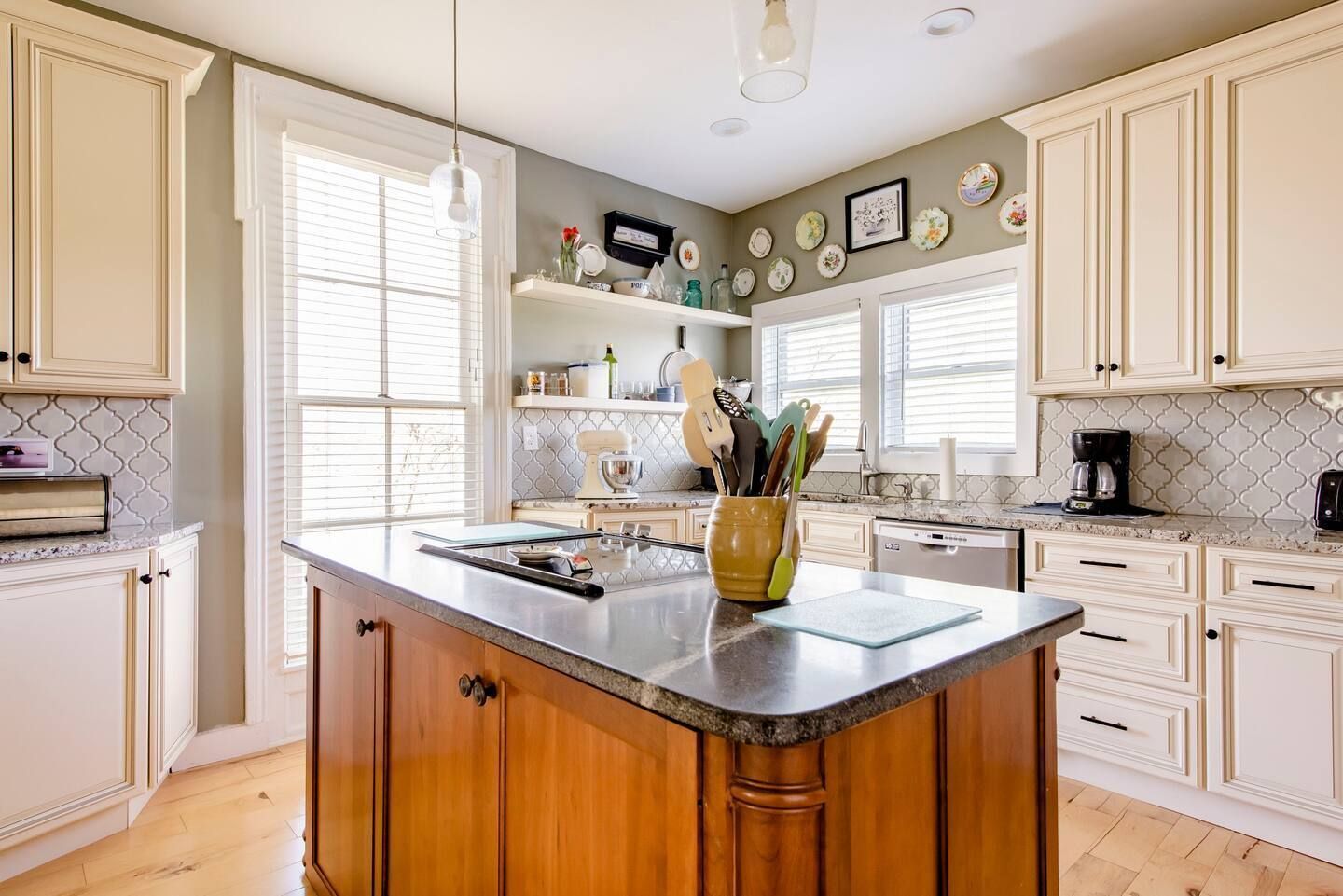 A kitchen with white cabinets and a large island in the middle.