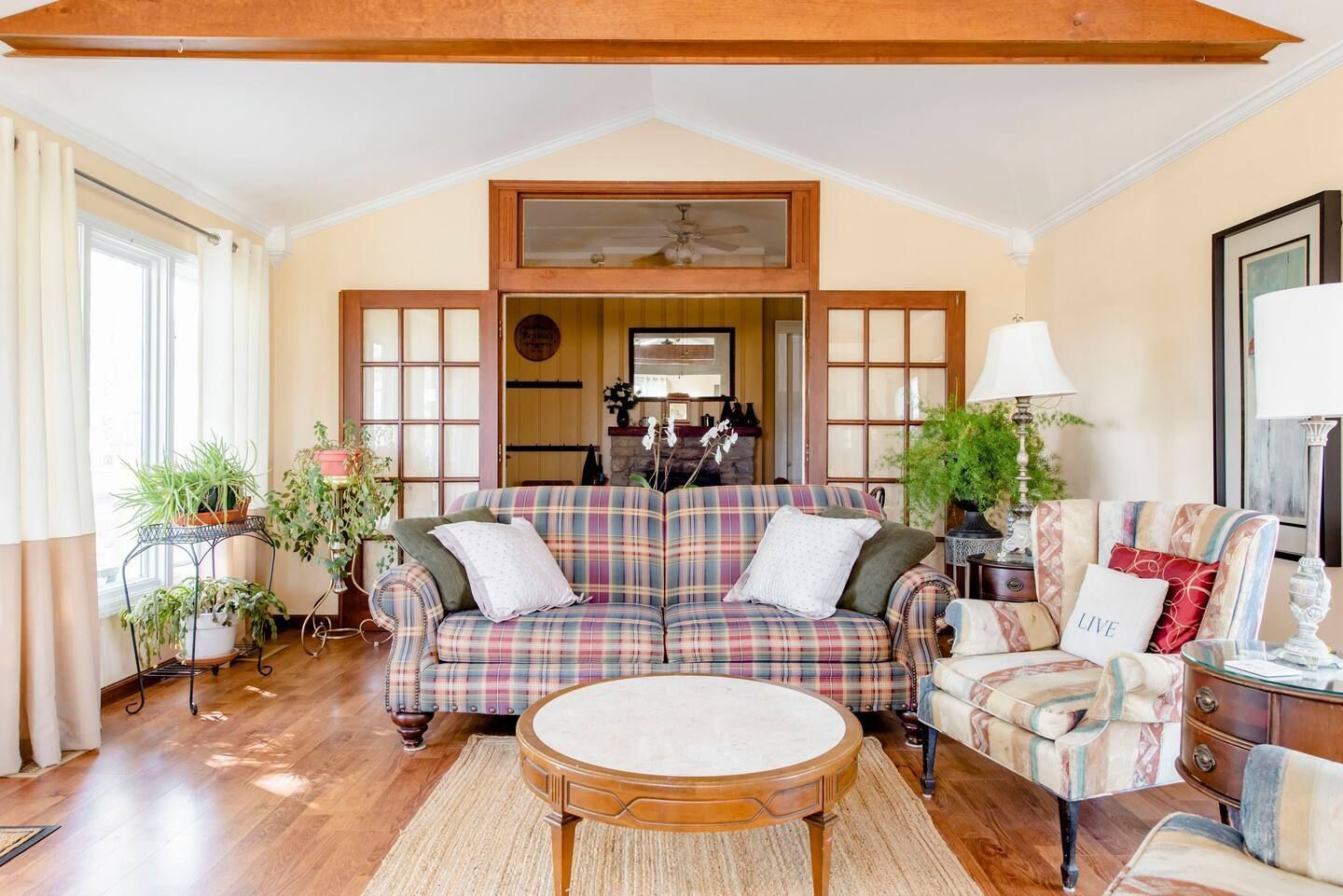 A living room with a couch , chairs , and a coffee table.