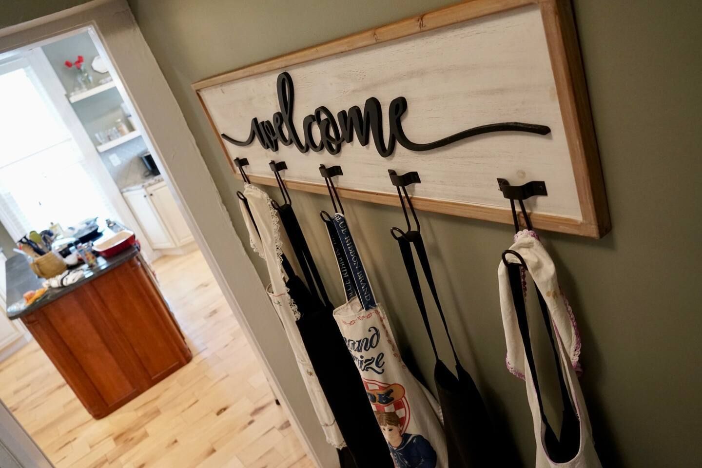 A sign that says welcome is hanging on a wall in a hallway.