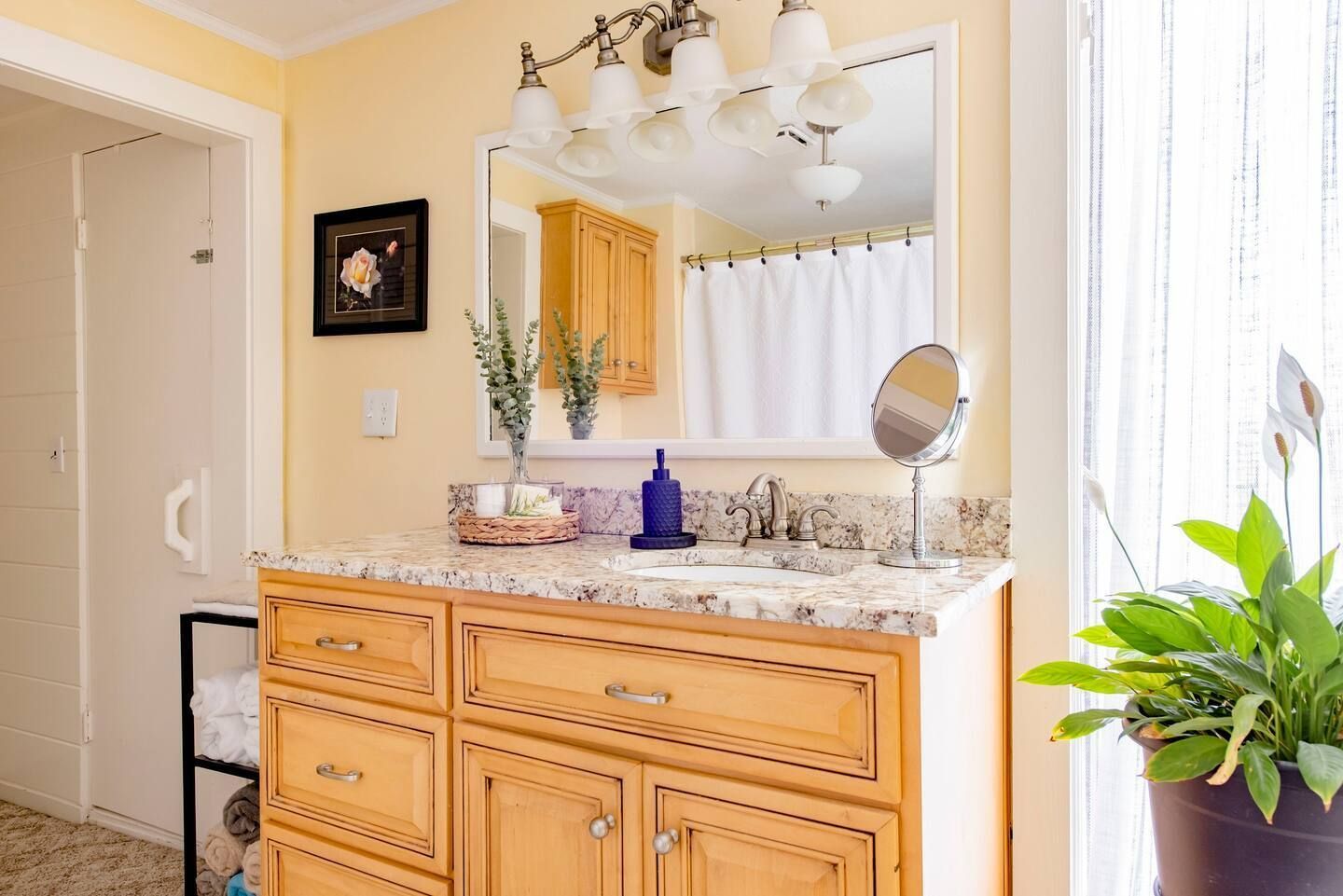 A bathroom with a sink , mirror , and cabinets.