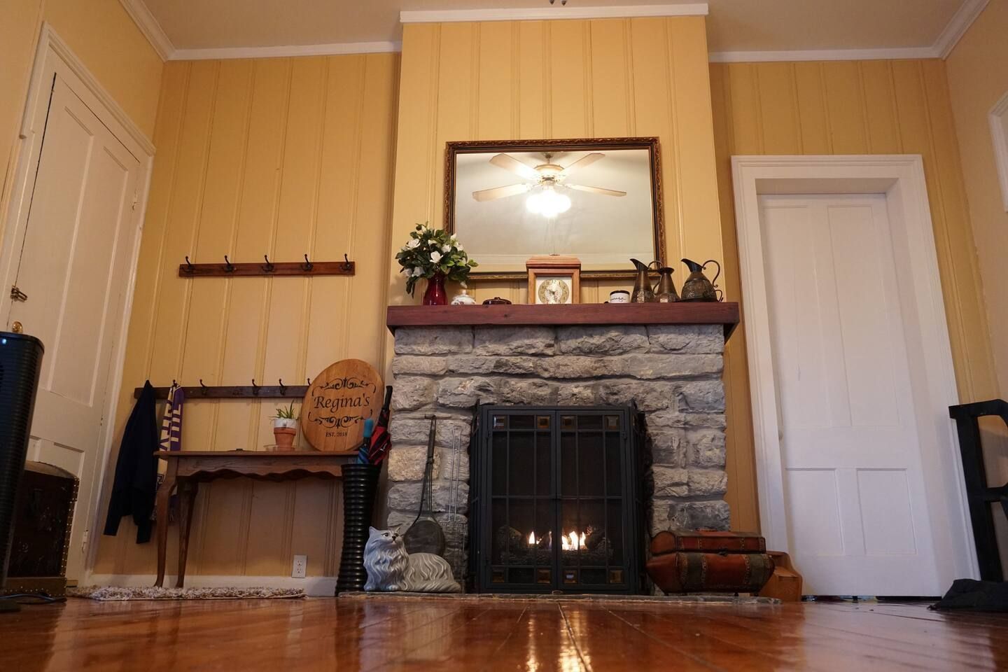 A living room with a fireplace and a mirror