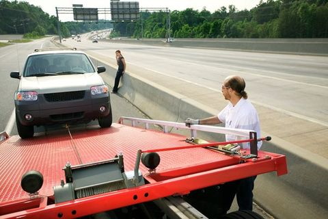 Roadside Assistance — Tow Truck Driver Loading Car in Medford, OR