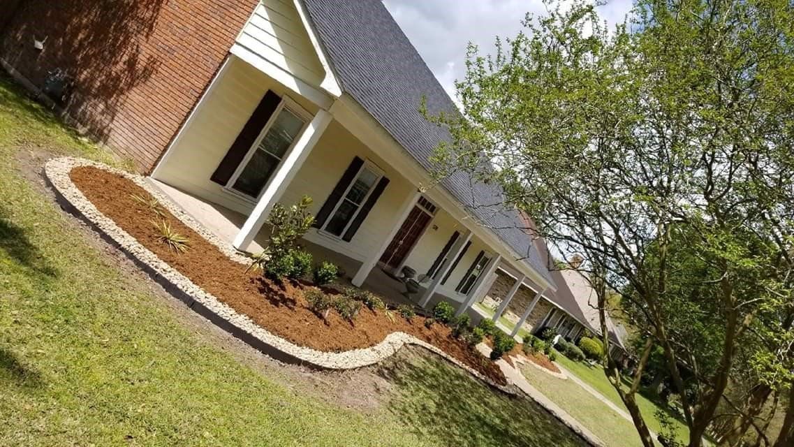 A house with a brick exterior, beige siding, and a landscaped front yard.