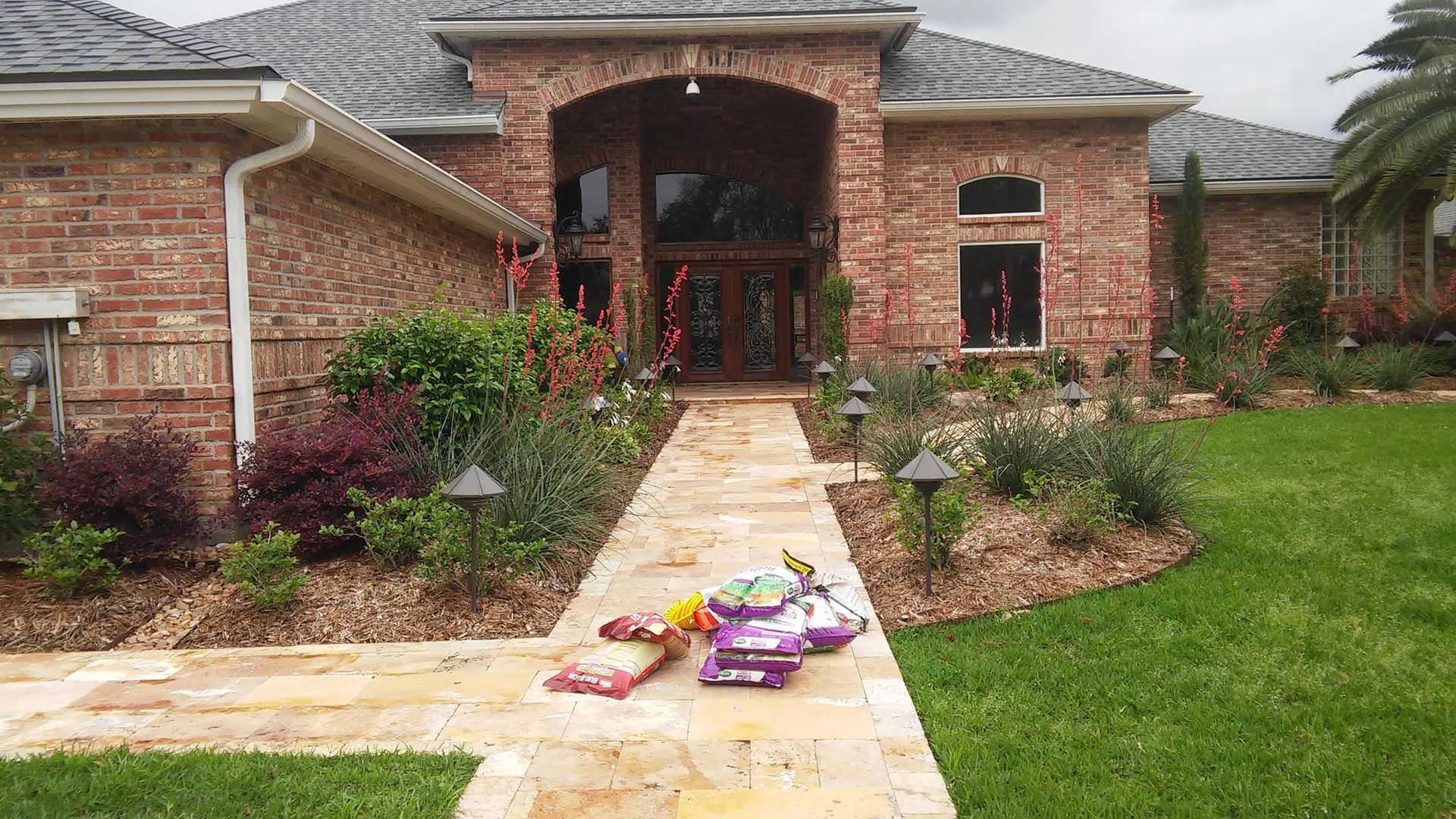 Brick house with stone path and landscaping; presents on path.