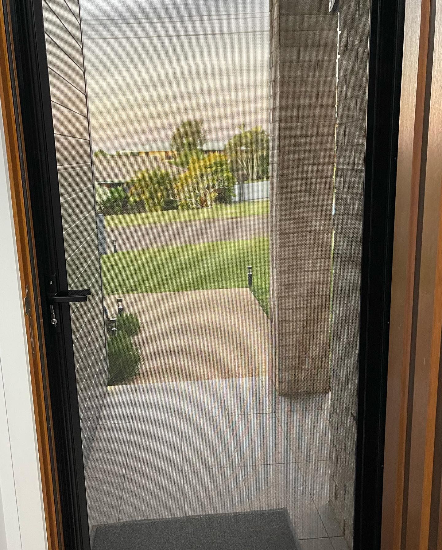 Screen Door Open View of Street and Yard — Moore Park Beach Glass & Security in Moore Park Beach, QLD