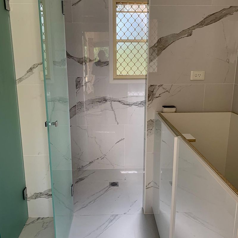 Bathroom With Marble Tiles and a Glass Shower Door — Moore Park Beach Glass & Security