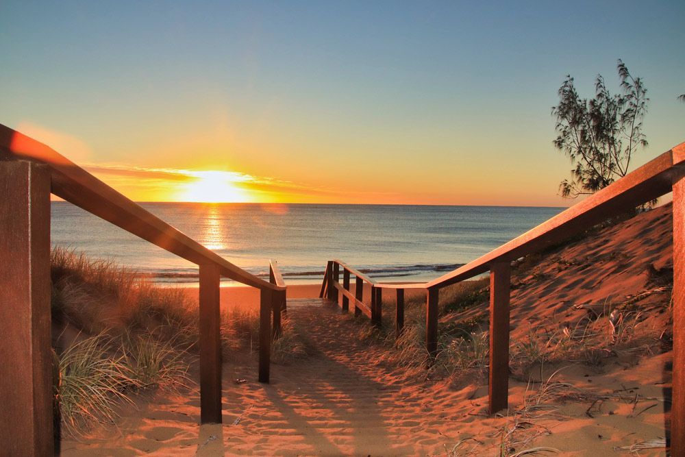 Wooden Staircase Leading to The Beach at Sunset — Moore Park Beach Glass & Security in Agnes Water