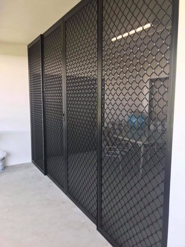 Black security screens on a building's exterior, with a diamond-shaped mesh design.