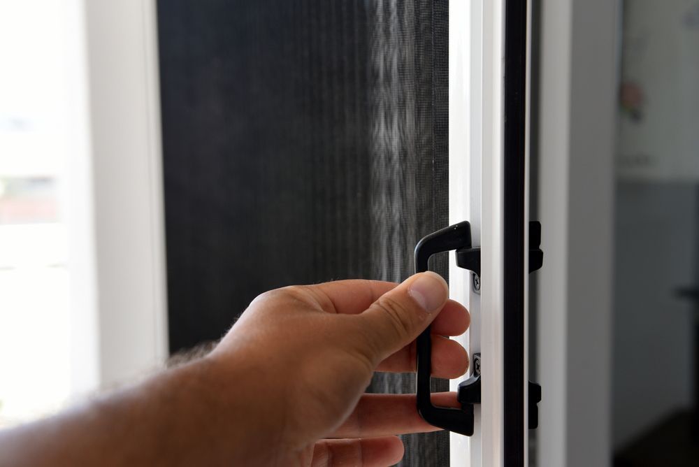 Hand Opening a Security Screen Door