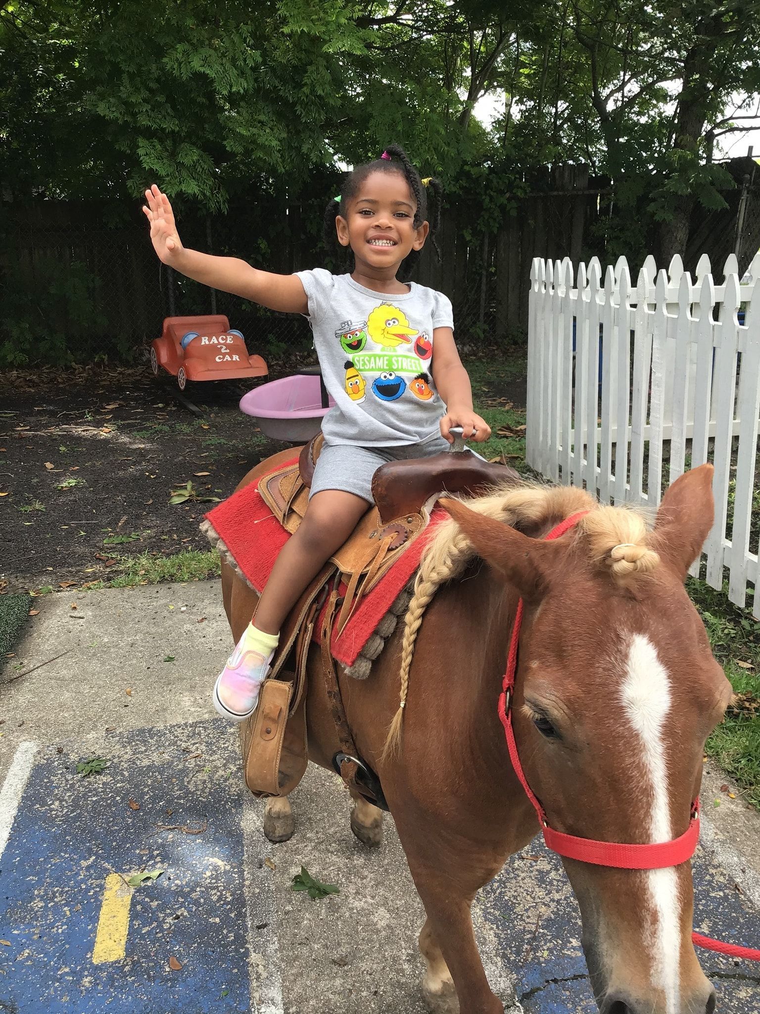 a little girl is riding on the back of a small brown horse .
