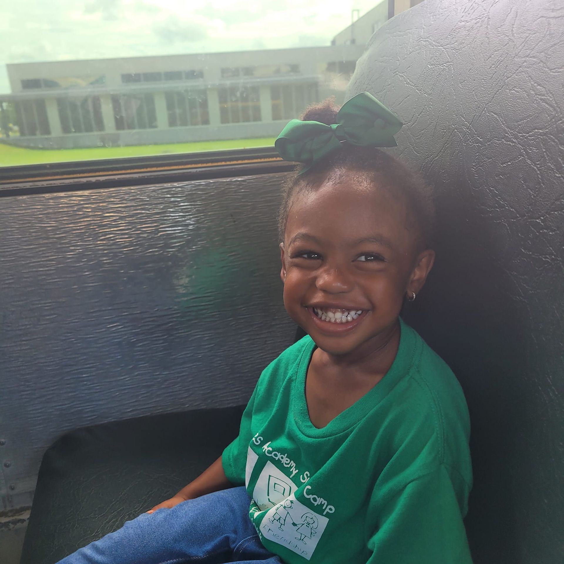 a little girl wearing a green shirt that says i 'm going to camp
