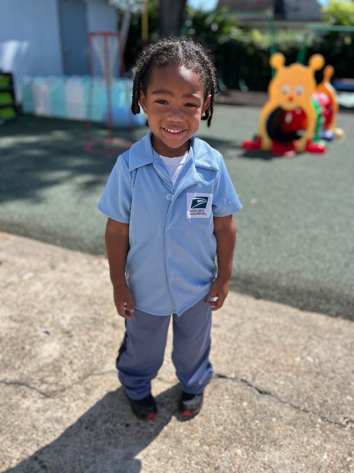 a little girl in a mailman costume is smiling for the camera