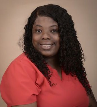 a woman with curly hair is wearing a red shirt and smiling .