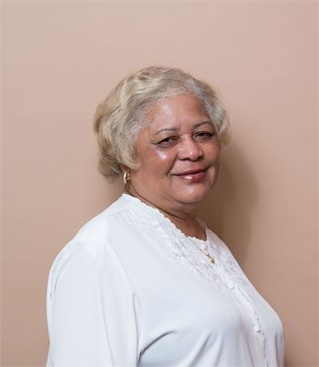 a woman in a white shirt is smiling for the camera .