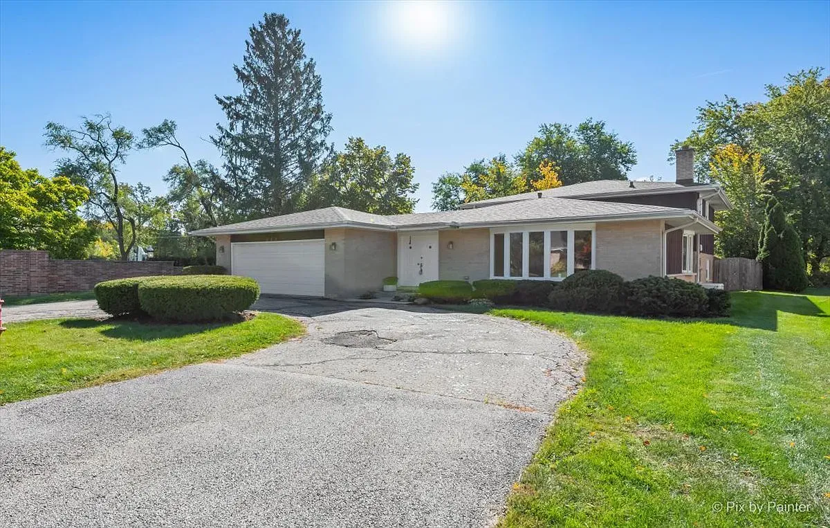 A house with a gravel driveway leading to it