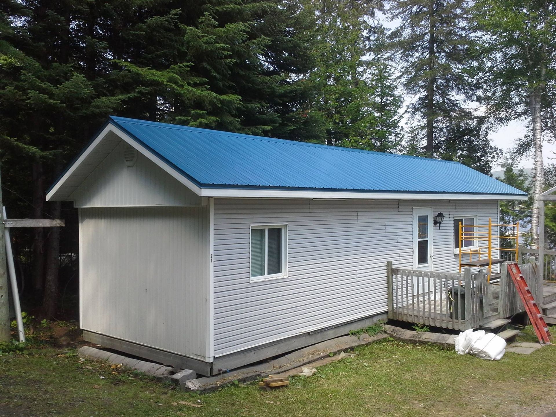 Une petite maison blanche avec un toit bleu