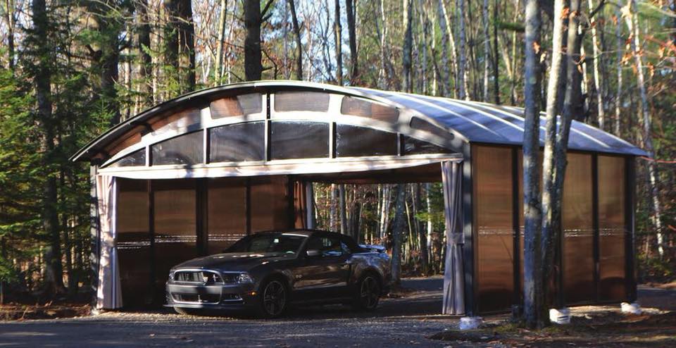 Une voiture est garée sous un abri voiture dans les bois.