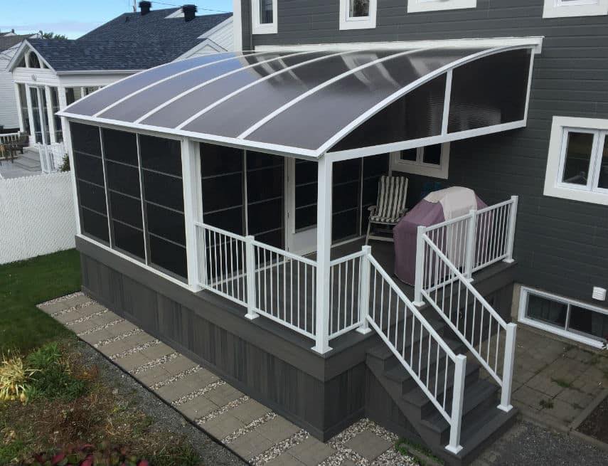 Une maison avec un porche grillagé et des escaliers qui y mènent.