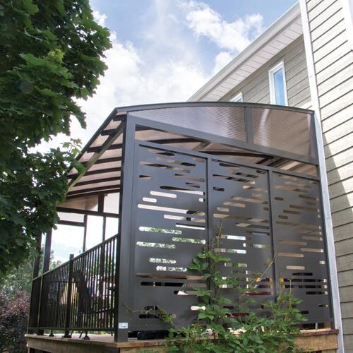 Une maison avec une terrasse couverte entourée d'une clôture