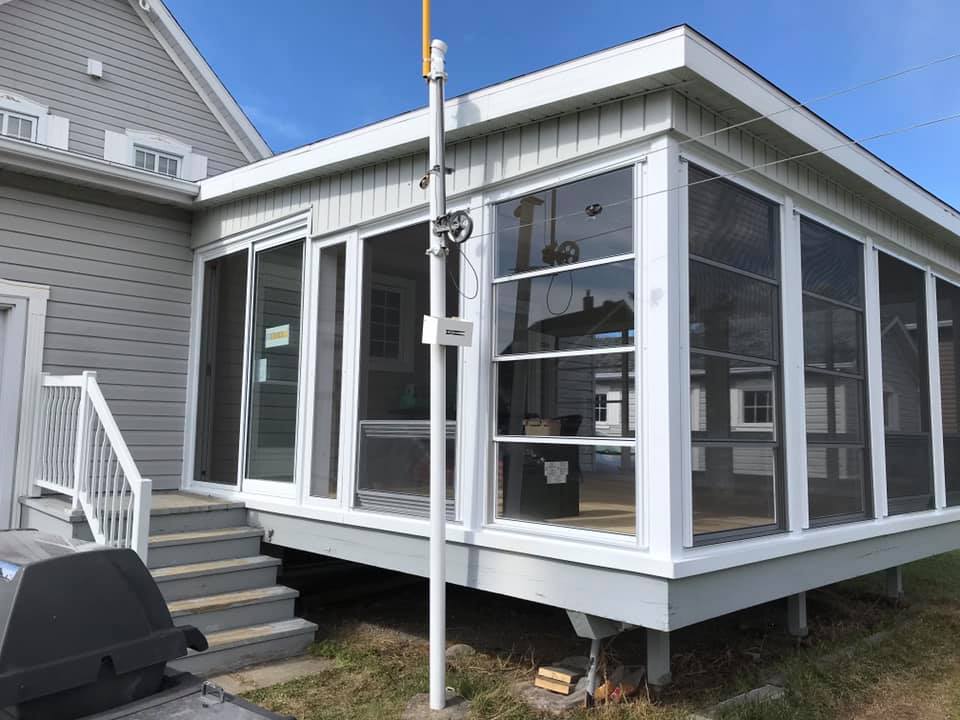 Un porche grillagé avec des escaliers menant à côté d'une maison.