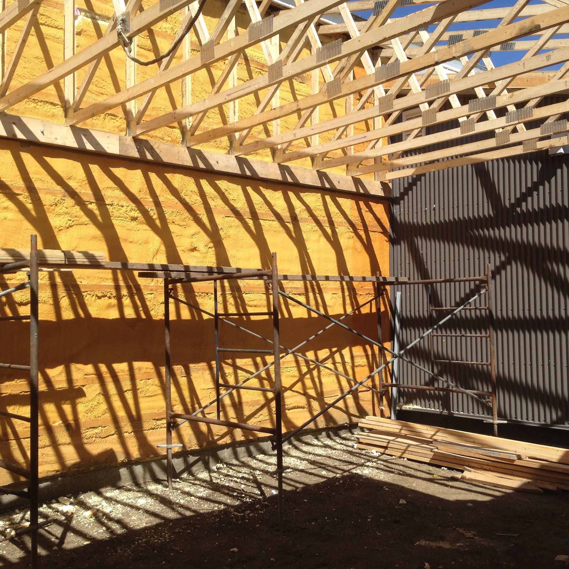 Un chantier avec des échafaudages et un mur jaune