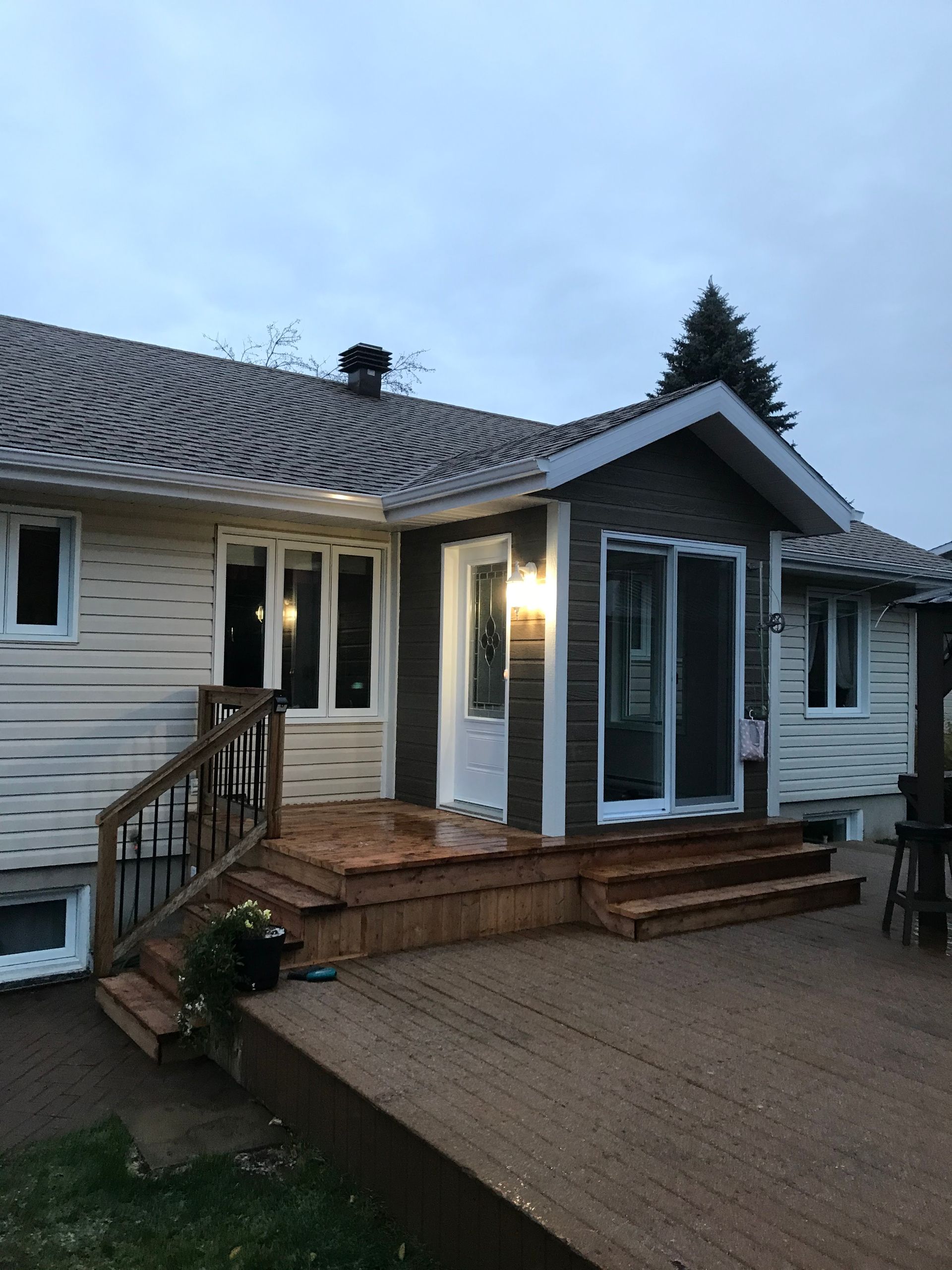 Une maison avec une terrasse et des escaliers devant.