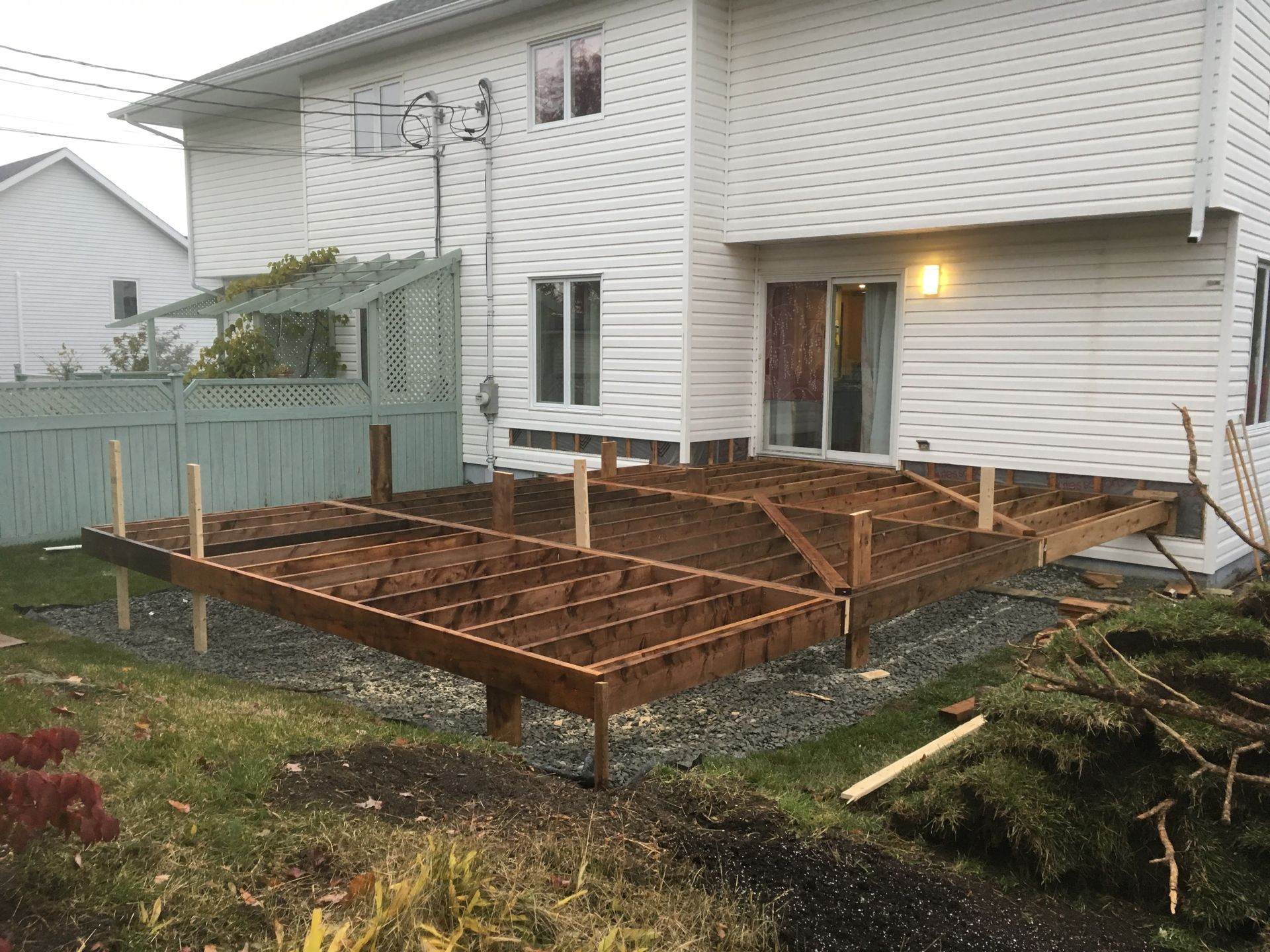 Une terrasse en bois est en cours de construction dans l'arrière-cour d'une maison.