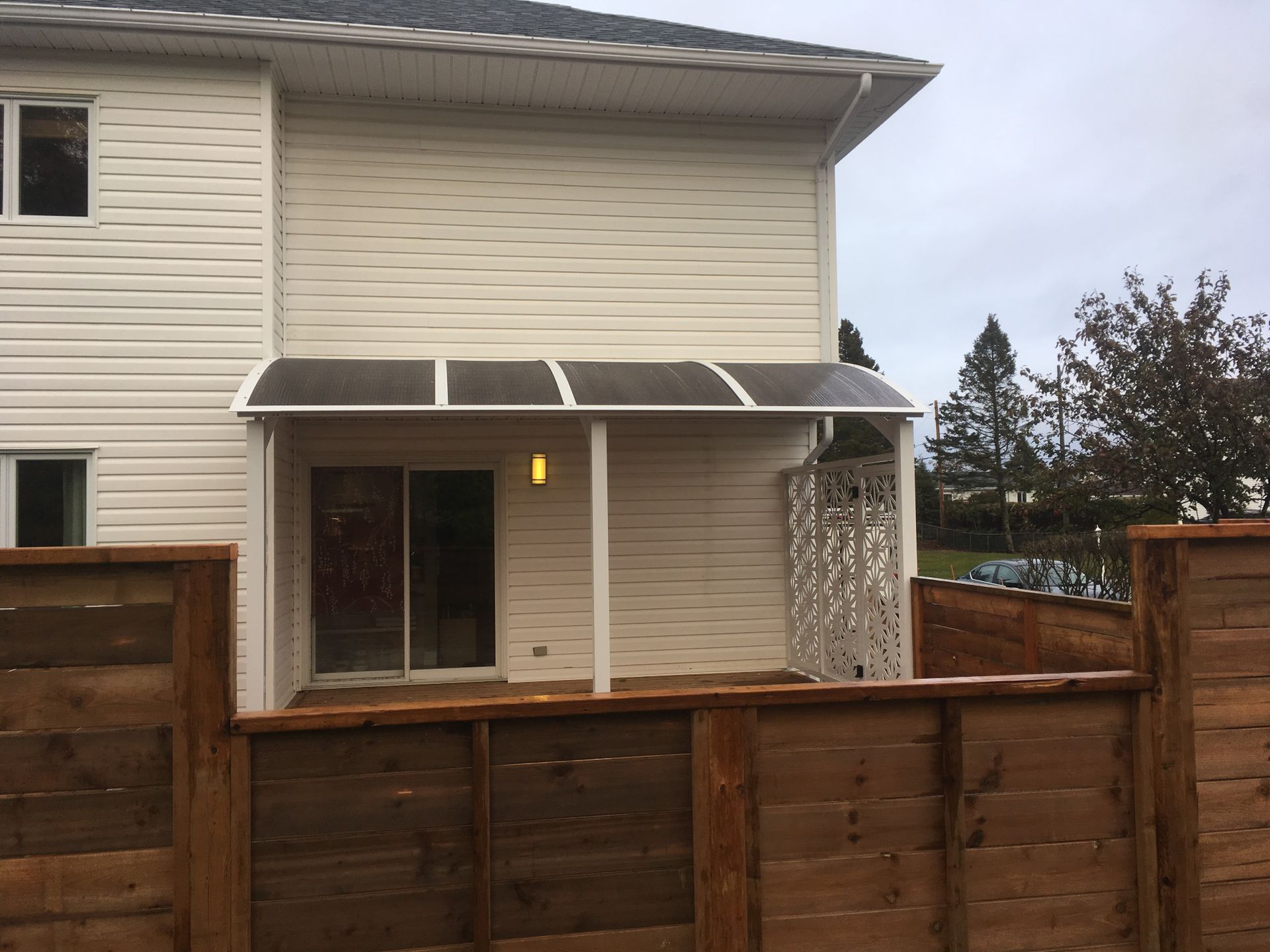 Une maison blanche avec une clôture en bois devant elle
