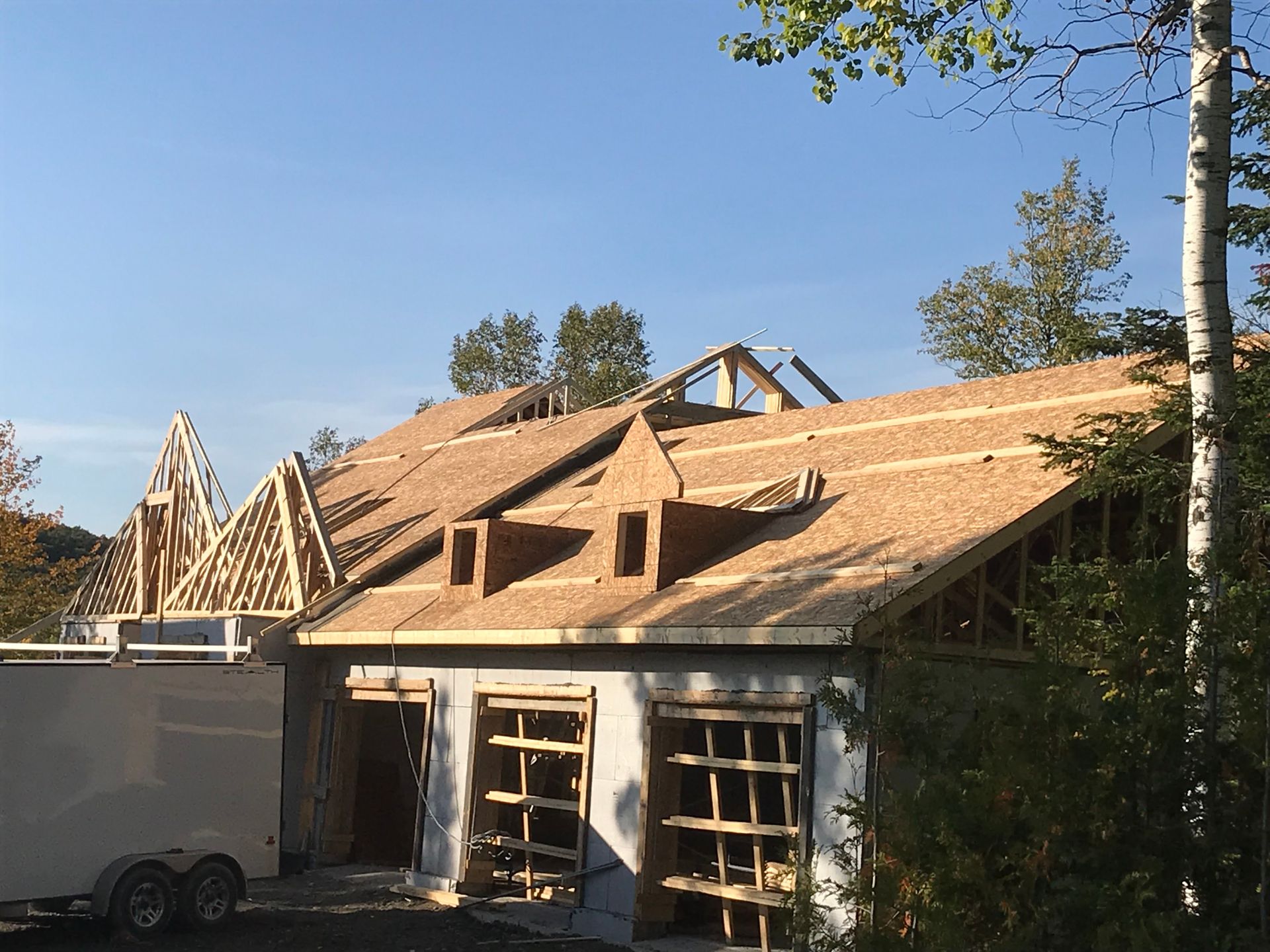 Une maison en construction avec une caravane garée devant.