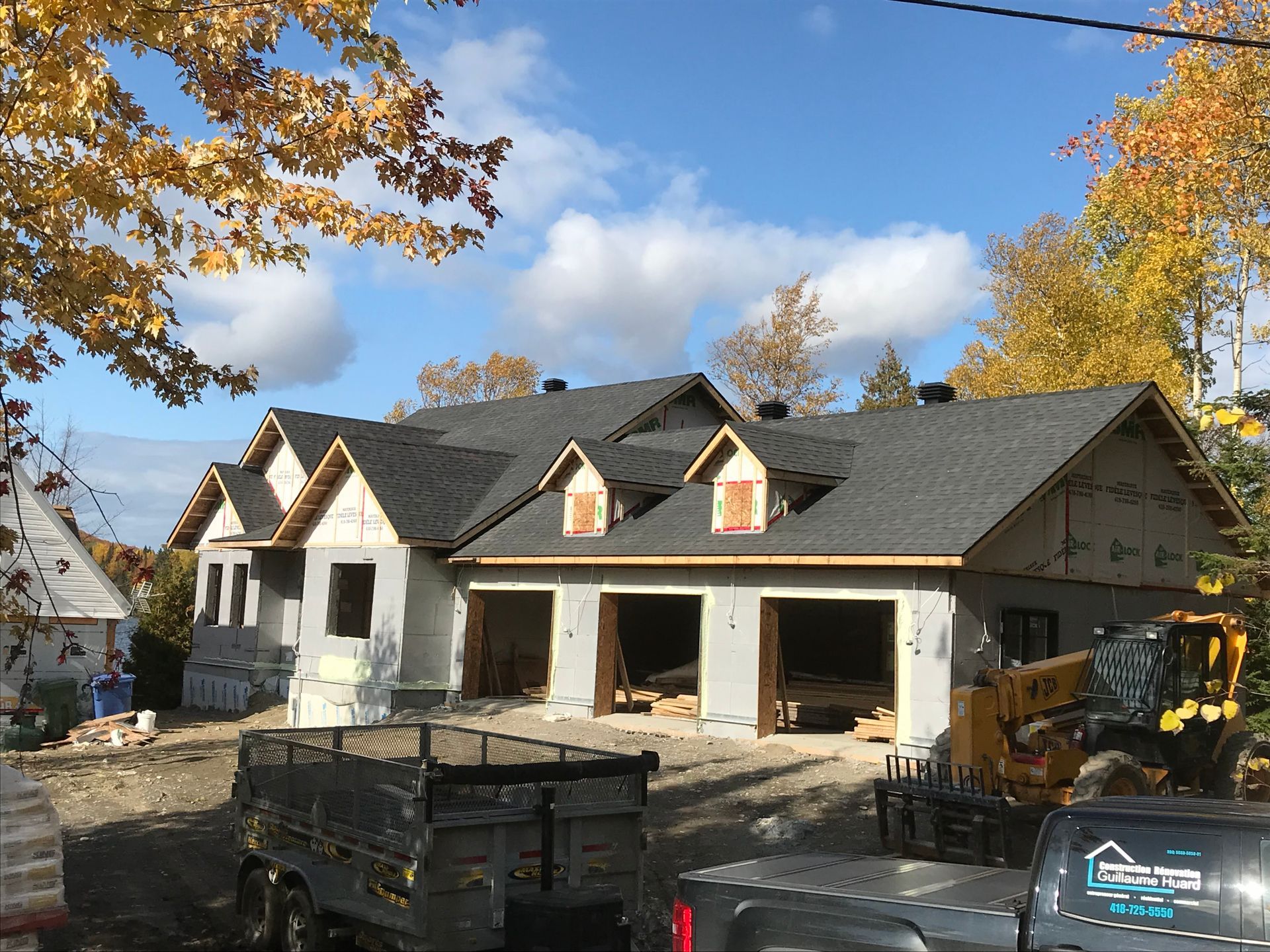 Un camion est garé devant une maison en construction.