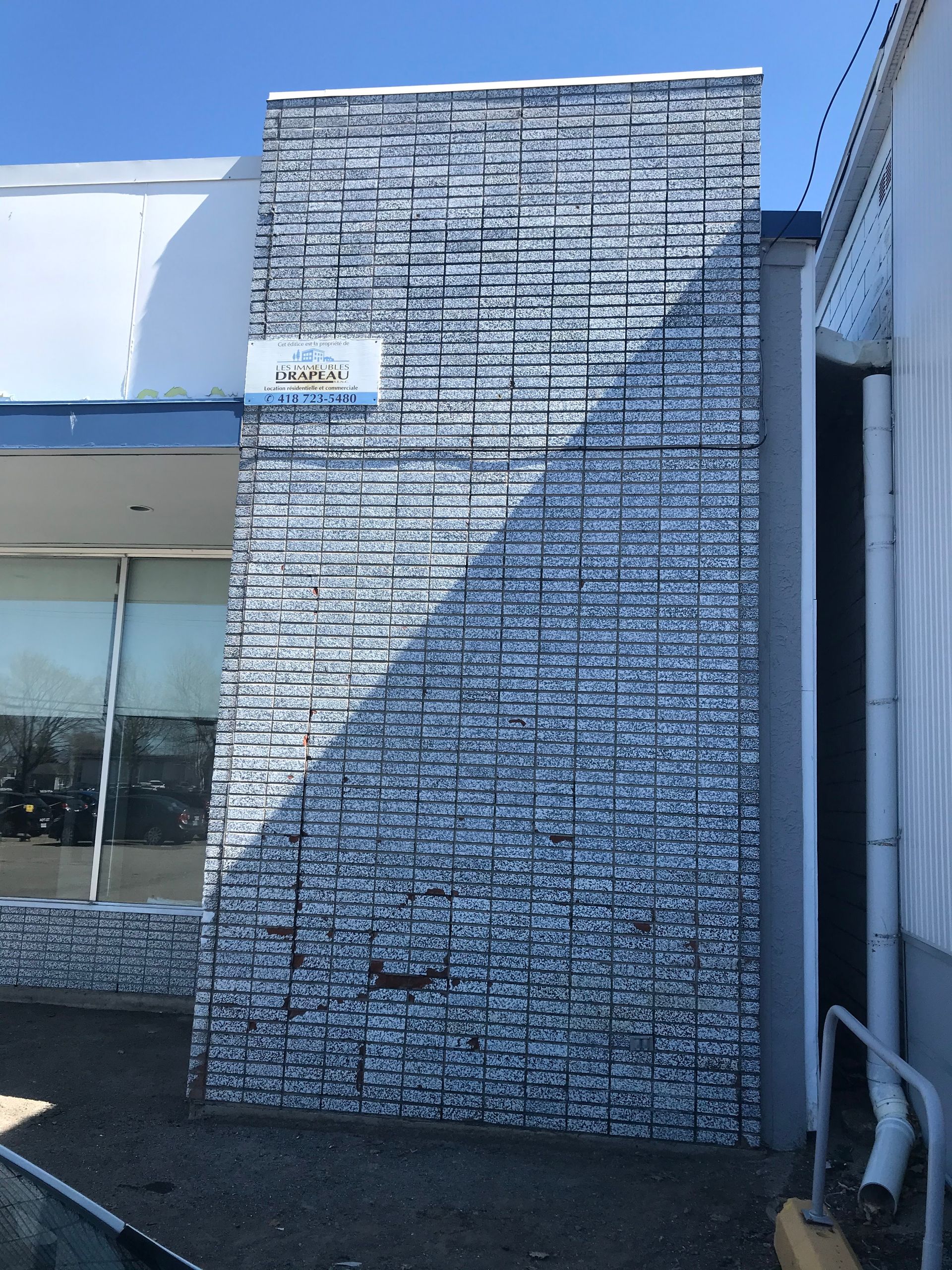 Un bâtiment blanc avec un mur de briques et un panneau indiquant « jcpenney » dessus