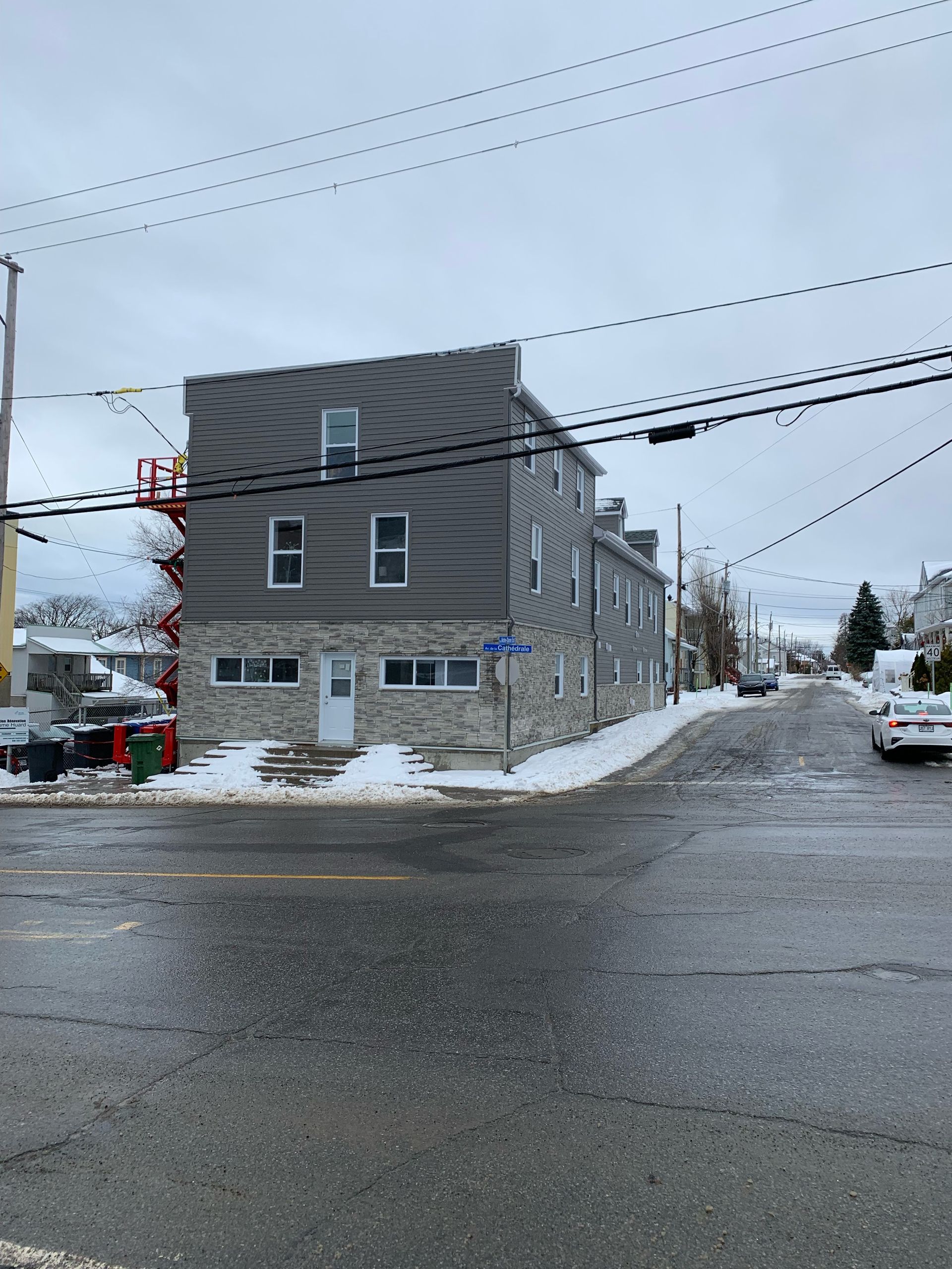 Un bâtiment avec un escalier de secours se trouve au coin d'une rue