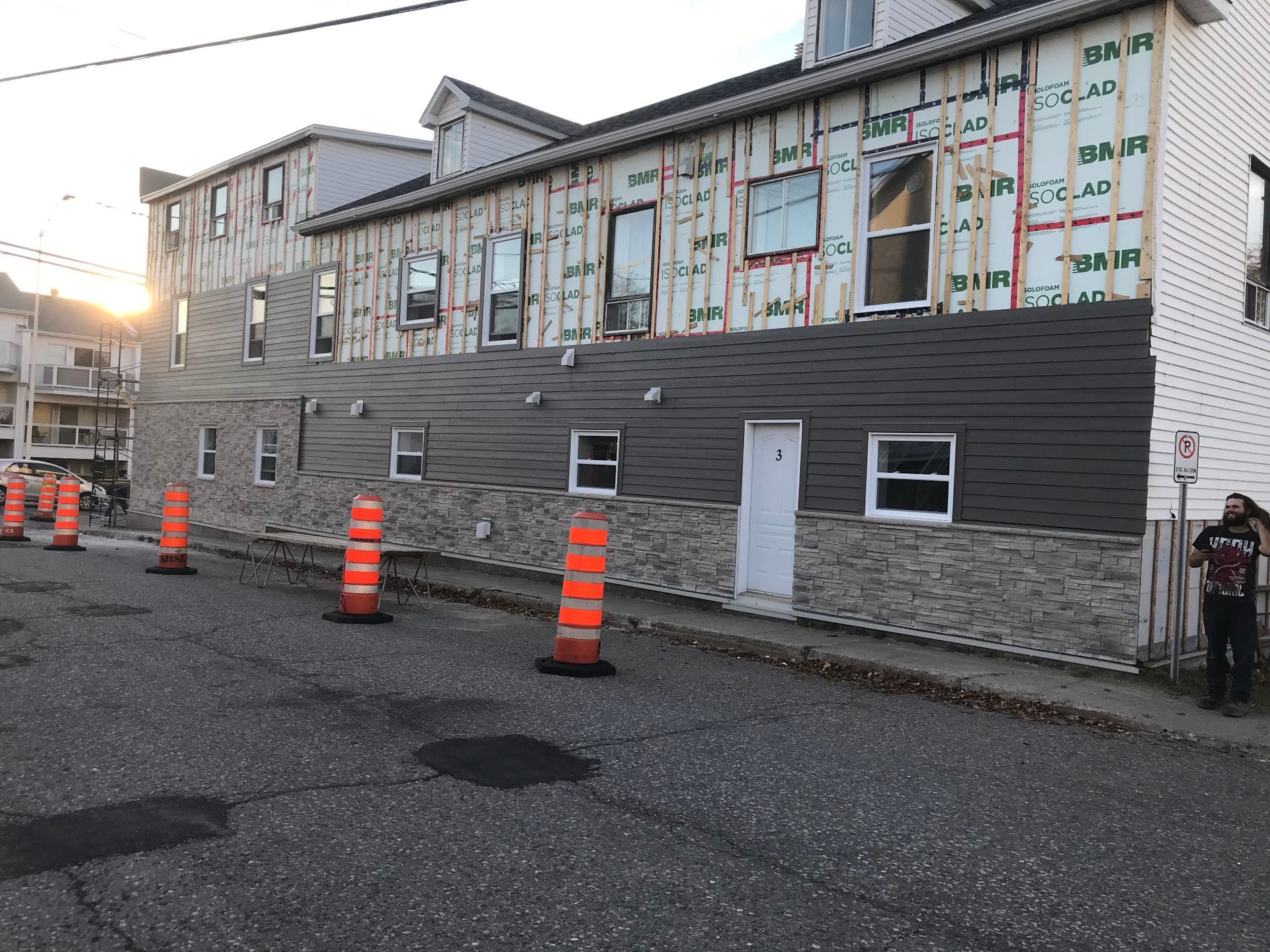 Un homme se tient devant un bâtiment en cours de rénovation.