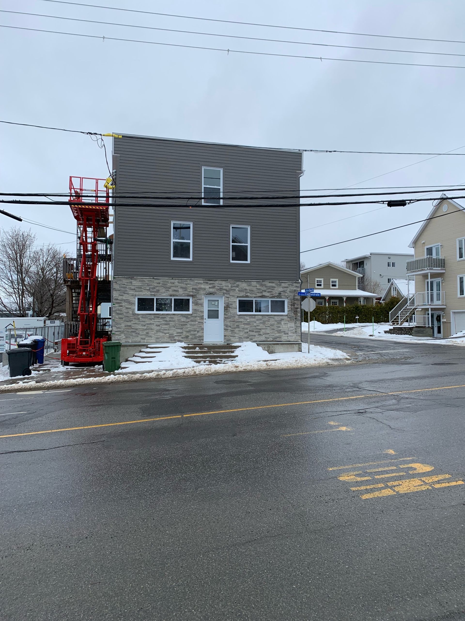 Un grand bâtiment avec un ascenseur rouge devant