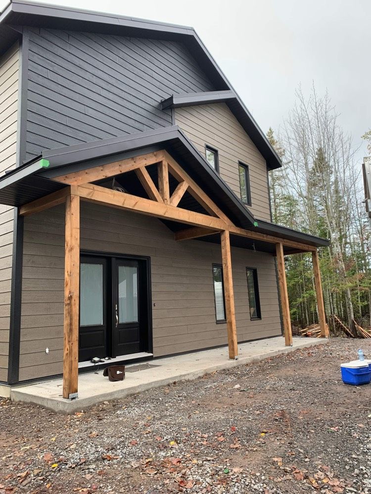 Une maison avec un porche et une glacière bleue devant.