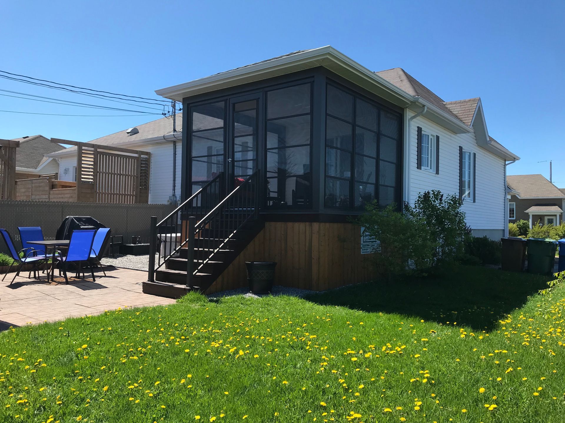 Il y a un porche grillagé dans l'arrière-cour d'une maison.