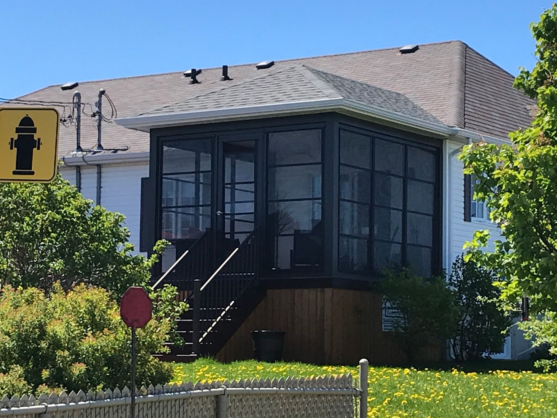 Une maison avec un porche grillagé et un panneau de borne d'incendie