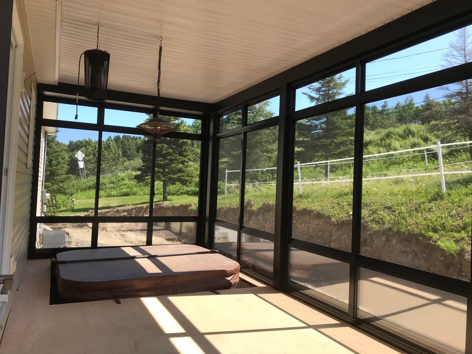 Un porche grillagé avec un bain à remous et de nombreuses fenêtres